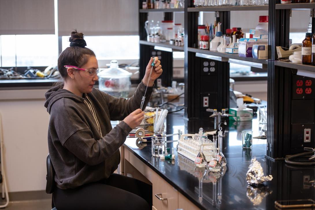 学生在化学实验室中使用移液管转移化学物质